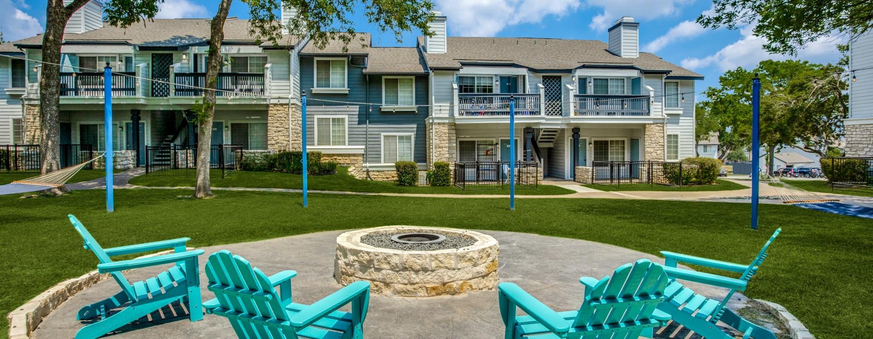 a group of blue chairs around a fire pit