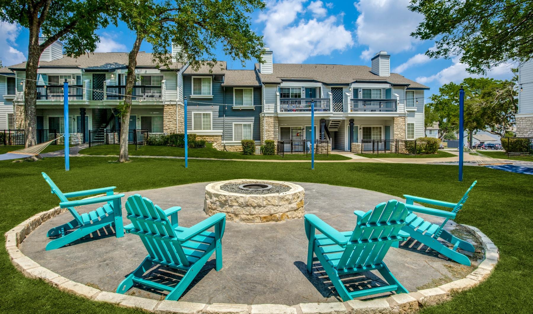a group of blue chairs around a fire pit
